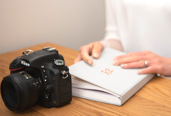 Picture by Victoria Murray of woman holding the Ponderlily planner with a camera.