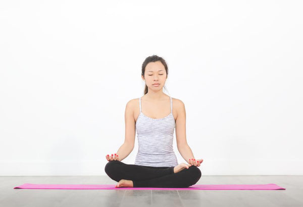Woman doing yoga, meditating, self-care.