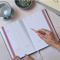 Woman writing in the calendar spread of the daily Ponderlily planner