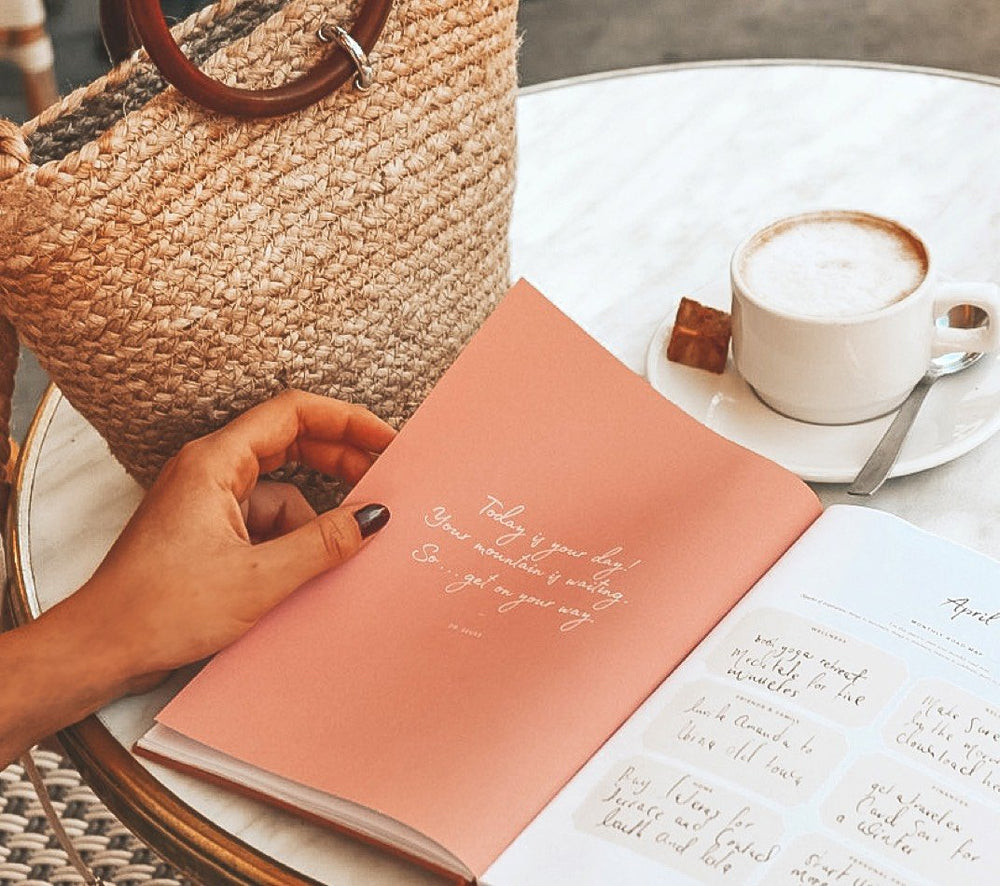 Ponderlily planner on table with mug and purse