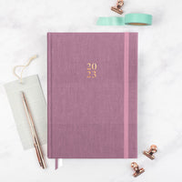2023 mauve planner by Ponderlily on desk with accessories
