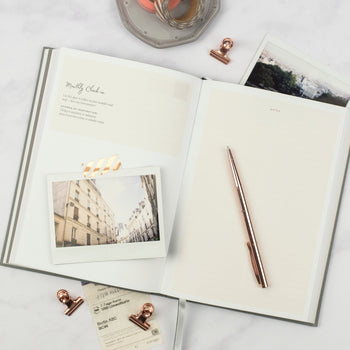 Ponderlily planner opened up to "monthly check-in" page with photo taped to page using washi tape and pen atop planner
