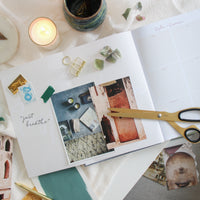 Inspiration and vision board in the Ponderlily planner with candles and scissors near