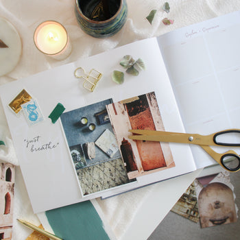 Inspiration and vision board in the Ponderlily planner with candles and scissors near